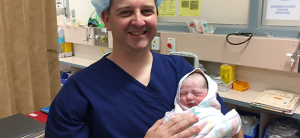Dr Darren Roberts with a newborn